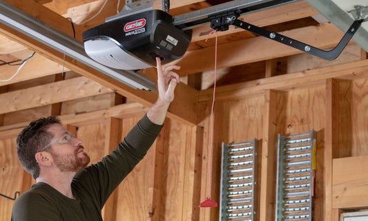 Man programming a Genie garage door opener installed