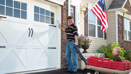 Father pulling a wagon with child opening the garage door with a wireless keypad 