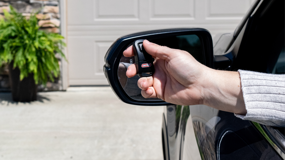 Hand holding a Genie garage door opener remote 